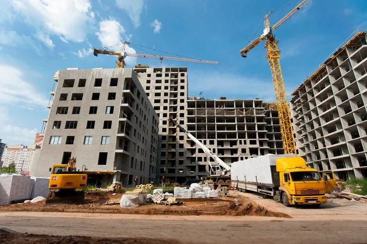 Apartment blocks under construction with cranes and trucks