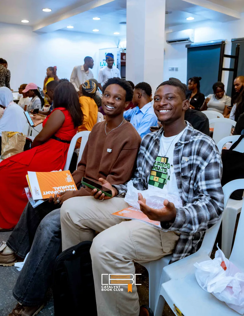 Young readers smiling with books at a Catalyst Book Club meet-up