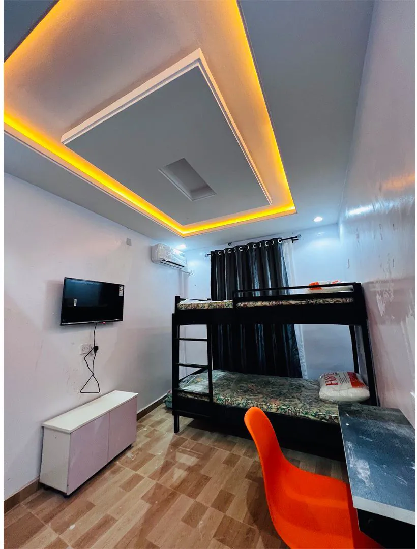Hostel room with study desk, TV and bunk bed