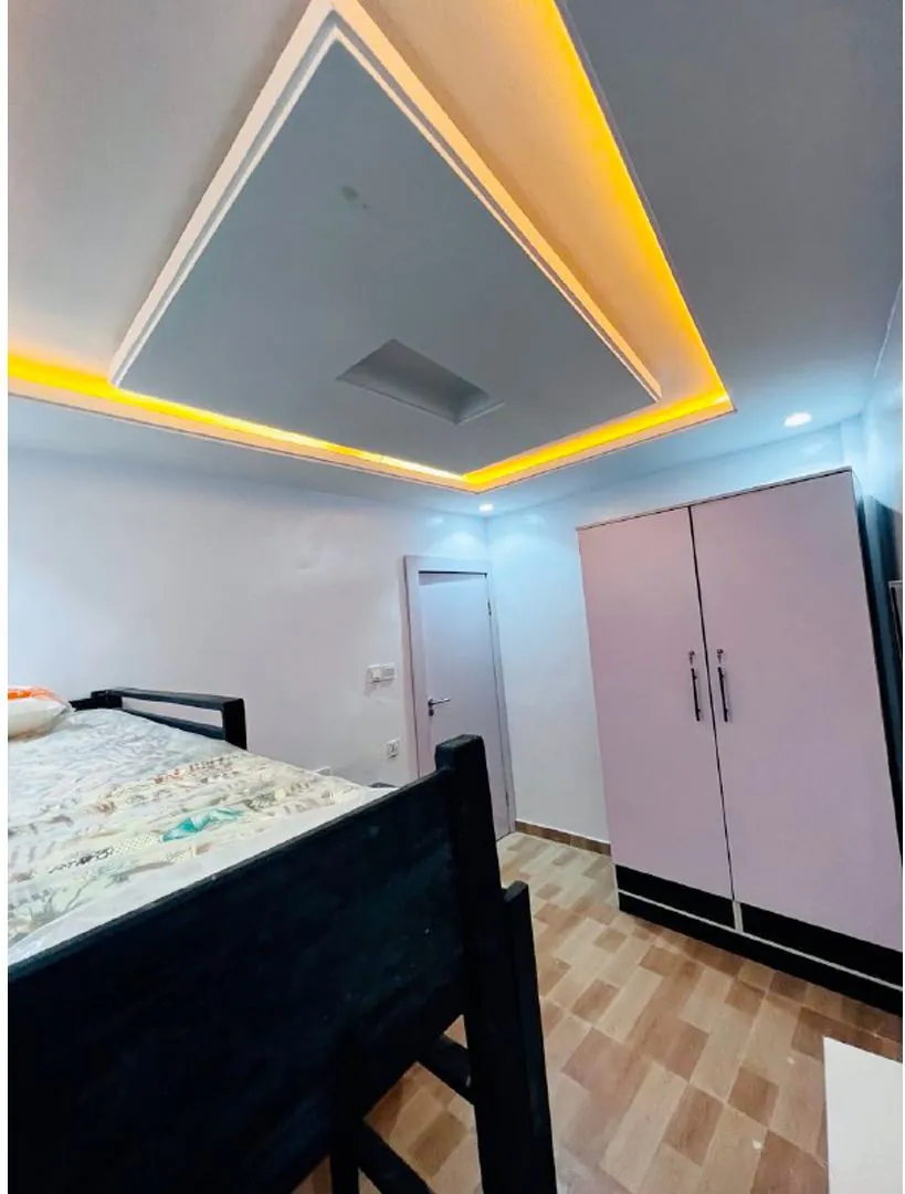 Furnished hostel room with bed and wardrobe